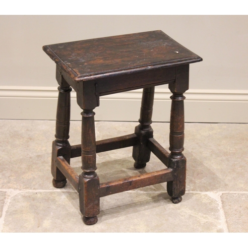 572 - An 18th century oak joint stool, the rectangular top with moulded rim raised upon ring incised legs ... 