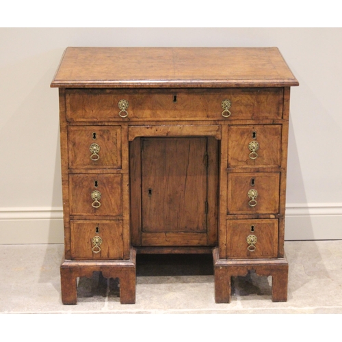 574 - A George II figured walnut kneehole desk, the quarter veneered and crossbanded top with a moulded ri... 