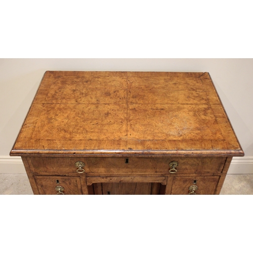 574 - A George II figured walnut kneehole desk, the quarter veneered and crossbanded top with a moulded ri... 