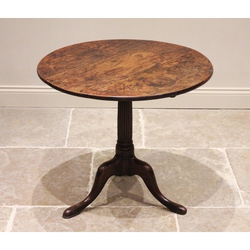 582 - A George III tripod table, the circular oak three plank top, raised upon an associated fluted column... 