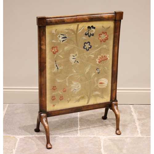 604 - * A mid-19th century mahogany framed crewel work inset fire screen, depicting a floral spray, raised... 