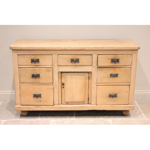 608 - * A Victorian pine dresser base, the slab top above an arrangement of seven drawers and a central cu... 