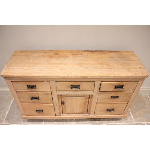 608 - * A Victorian pine dresser base, the slab top above an arrangement of seven drawers and a central cu... 