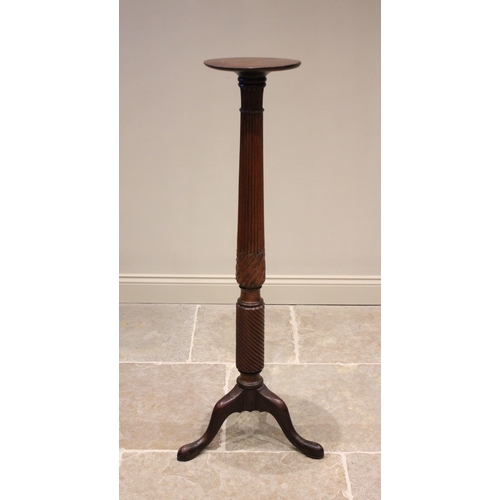 613 - A 19th century mahogany torchere, the circular top raised upon a reeded and wrythen column, extendin... 