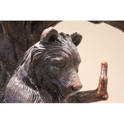 618 - A 19th century Black Forest figural oak hall stand, naturalistically carved as a cub bear hanging fr... 