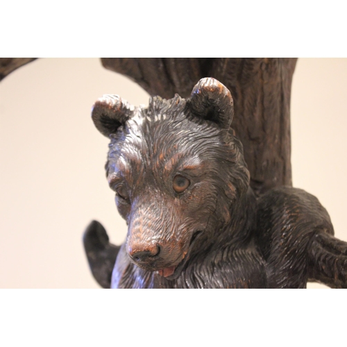 618 - A 19th century Black Forest figural oak hall stand, naturalistically carved as a cub bear hanging fr... 