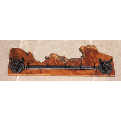 623 - * A wall mounted cast iron and yew wood hat/coat rack, the rough cut timber applied with two cast ir... 