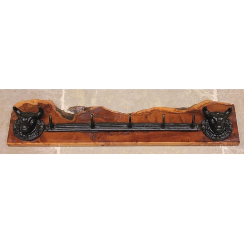 624 - * A wall mounted cast iron and yew wood hat/coat rack, the rough cut timber applied with two cast ir... 