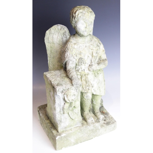 86 - A carved stone model of an angel, modelled holding a cross and leaning upon a plinth, 49.5cm high (a... 