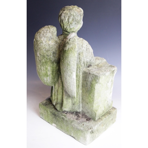 86 - A carved stone model of an angel, modelled holding a cross and leaning upon a plinth, 49.5cm high (a... 