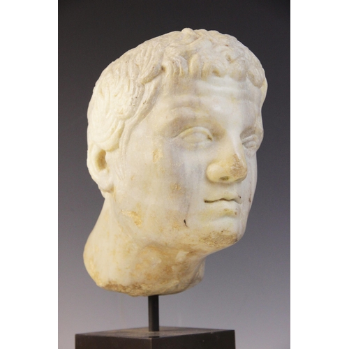 90 - A carved marble male head, in the Roman manner, with curling hair and well defined features, un-carv... 