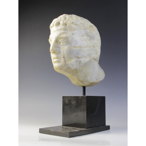 90 - A carved marble male head, in the Roman manner, with curling hair and well defined features, un-carv... 