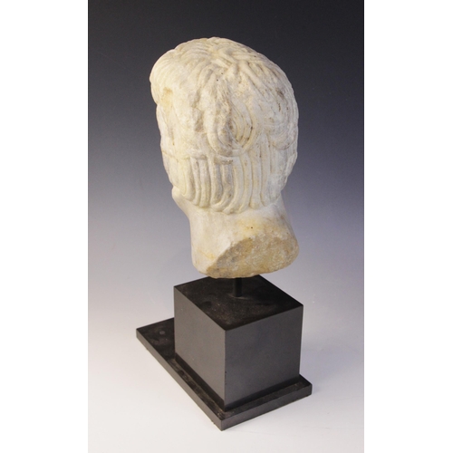 90 - A carved marble male head, in the Roman manner, with curling hair and well defined features, un-carv... 