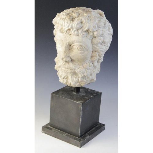 96 - A carved stone head, the male head distinctively carved with curled hair and beard, 29cm high, mount... 