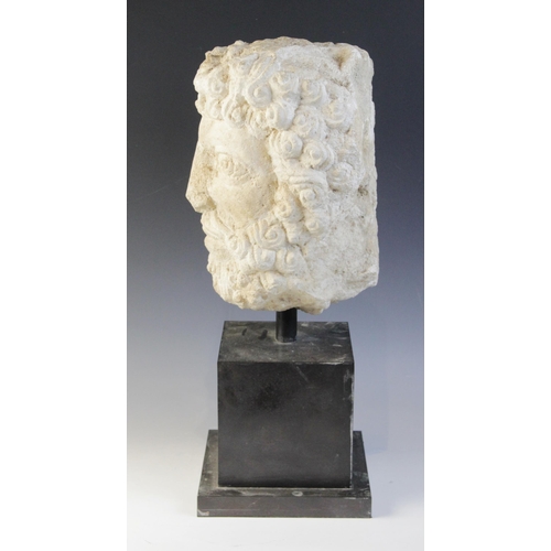 96 - A carved stone head, the male head distinctively carved with curled hair and beard, 29cm high, mount... 