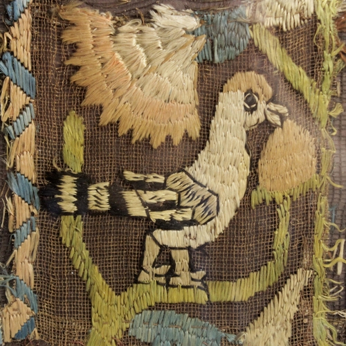 263 - An early 18th century embroidery fragment, the square panel depicting a hoopoe bird in a floral surr... 