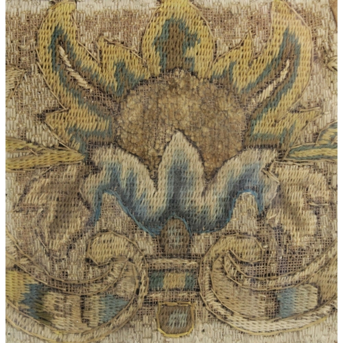 263 - An early 18th century embroidery fragment, the square panel depicting a hoopoe bird in a floral surr... 