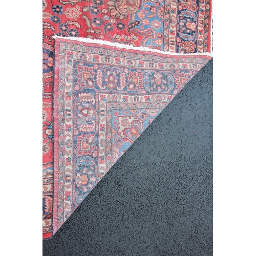 271 - * A Persian pattern wool rug, having a central blue medallion on a red ground, enclosed by foliate u... 