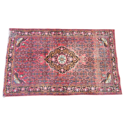 273 - * A Persian pattern wool rug, of traditional design, the central foliate lozenge upon a red ground w... 