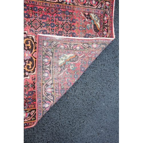 273 - * A Persian pattern wool rug, of traditional design, the central foliate lozenge upon a red ground w... 