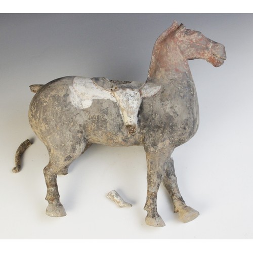 334 - A Chinese pottery model of a figure riding a horse, possibly Han dynasty, the horse standing on four... 