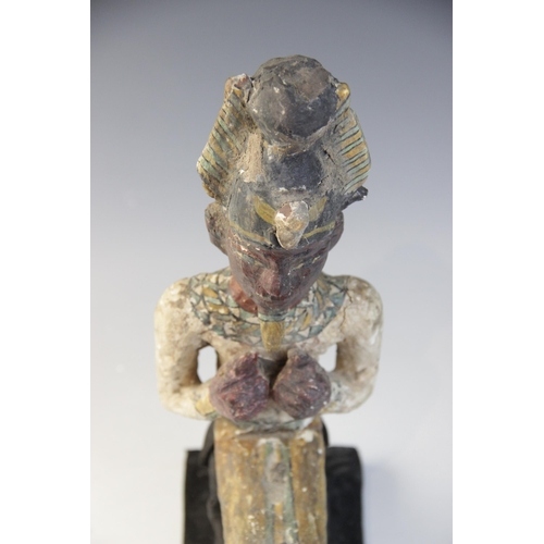 120 - An Egyptian style gesso painted seated wood figure of a pharaoh, wearing the atef crown, Not Ancient... 