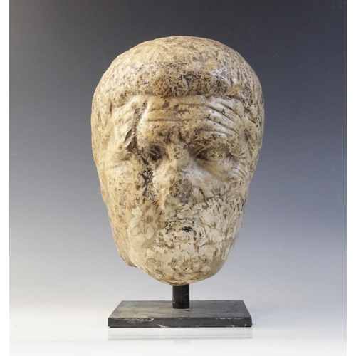 122 - A worn marble male head carved with deeply furrowed brow, with restorations, 26cm high (at fault) 

... 