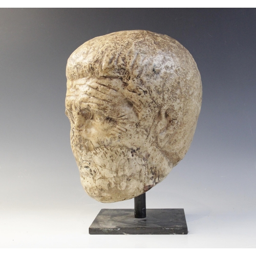 122 - A worn marble male head carved with deeply furrowed brow, with restorations, 26cm high (at fault) 

... 