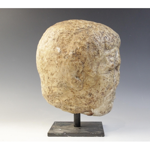 122 - A worn marble male head carved with deeply furrowed brow, with restorations, 26cm high (at fault) 

... 