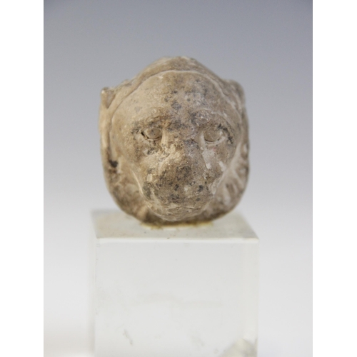 128 - An Egyptian Middle Kingdom alabaster kohl vessel, circa 2000 B.C., 6cm high and a limestone head of ... 