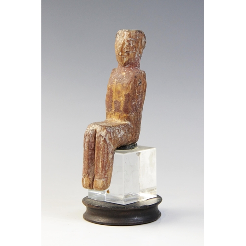 131 - An Egyptian polychrome painted wood model figure, shown seated with arms missing, wearing a short wi... 