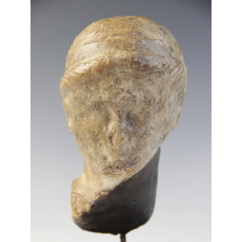 138 - A marble female head, features worn, her hair held in place beneath a fillet, 20cm high (at fault) 
... 