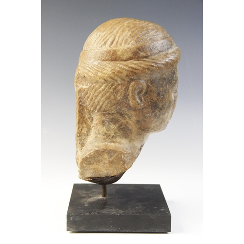 138 - A marble female head, features worn, her hair held in place beneath a fillet, 20cm high (at fault) 
... 