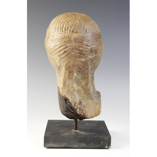 138 - A marble female head, features worn, her hair held in place beneath a fillet, 20cm high (at fault) 
... 