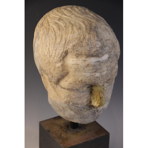 146 - A worn marble male head carved with furrowed brow, with restorations, height excluding base approxim... 