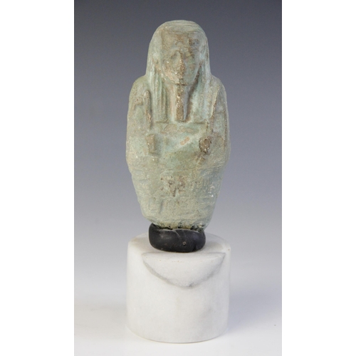 159 - A fragmentary Egyptian blue glazed faience shabti, holding a pick and a hoe, worn bands of horizonta... 