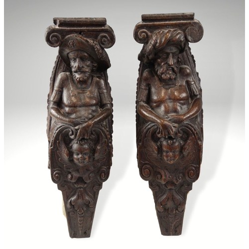 436 - A pair of 17th century oak figural terms, Flemish, each carved with a male bust wearing a hat above ... 