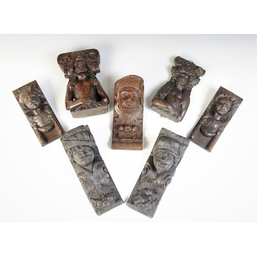 458 - A group of seven oak figural corbels, including a pair of male masks with plumed headdress 20cm high... 