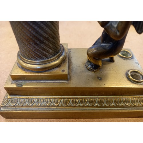 48 - A brass desk inkwell, 19th century, designed as a cherub kneeling before a memorial plinth, surmount... 