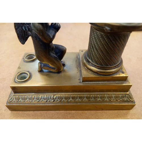 48 - A brass desk inkwell, 19th century, designed as a cherub kneeling before a memorial plinth, surmount... 