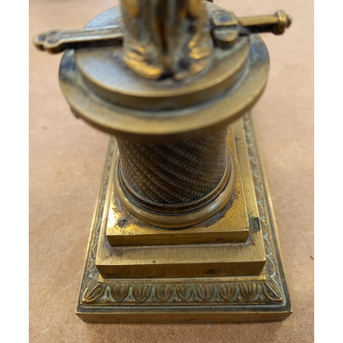48 - A brass desk inkwell, 19th century, designed as a cherub kneeling before a memorial plinth, surmount... 