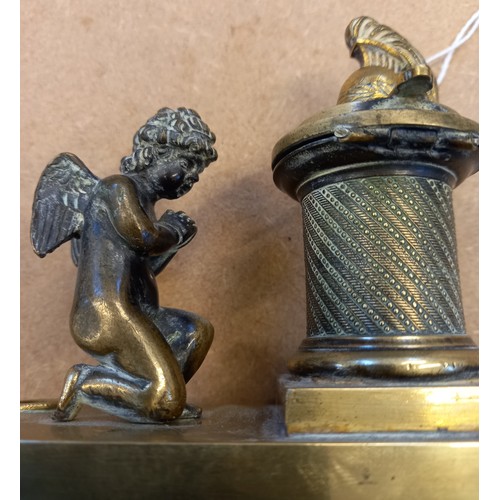 48 - A brass desk inkwell, 19th century, designed as a cherub kneeling before a memorial plinth, surmount... 