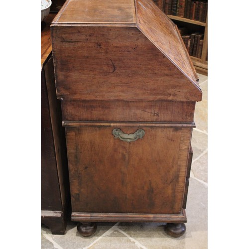 560 - A William and Mary and later figured walnut bureau, in two sections, the feather banded fall front o... 