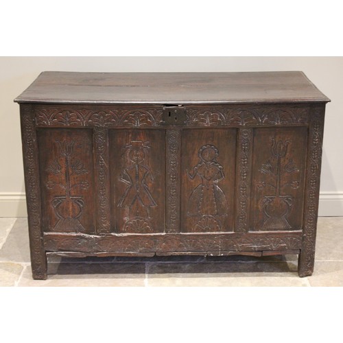 525 - An early 17th century tall oak coffer, the twin board top with a moulded rim, above a frieze carved ... 