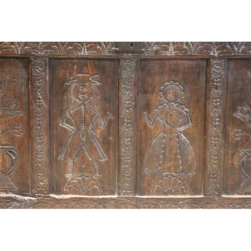 525 - An early 17th century tall oak coffer, the twin board top with a moulded rim, above a frieze carved ... 