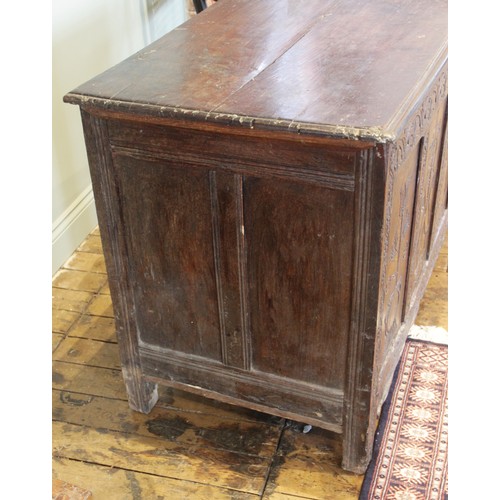 525 - An early 17th century tall oak coffer, the twin board top with a moulded rim, above a frieze carved ... 