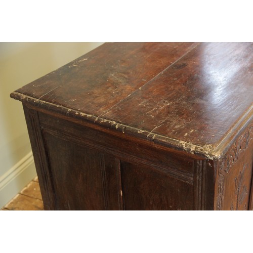 525 - An early 17th century tall oak coffer, the twin board top with a moulded rim, above a frieze carved ... 