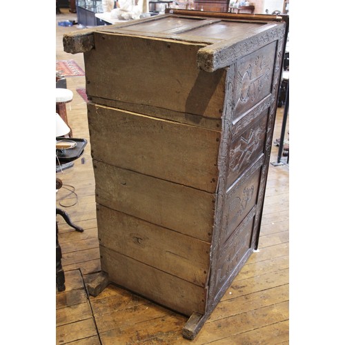 525 - An early 17th century tall oak coffer, the twin board top with a moulded rim, above a frieze carved ... 