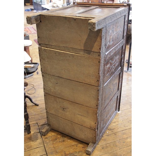 525 - An early 17th century tall oak coffer, the twin board top with a moulded rim, above a frieze carved ... 