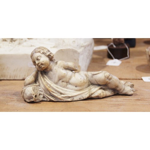 107 - A carved marble fragment depicting a reclining putto with draped material, 22cm long, 10cm high (at ... 